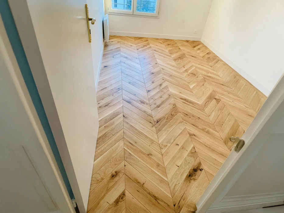 Intérieur résidentiel moderne avec sol en parquet massif chêne naturel disposé en motif chevron ou point de Hongrie