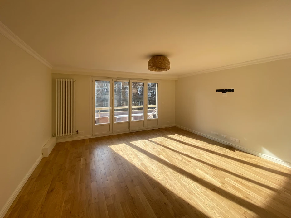 Chambre de bébé moderne avec lit à barreaux blanc, armoire haute couleur pêche à quatre portes et compartiments supérieurs