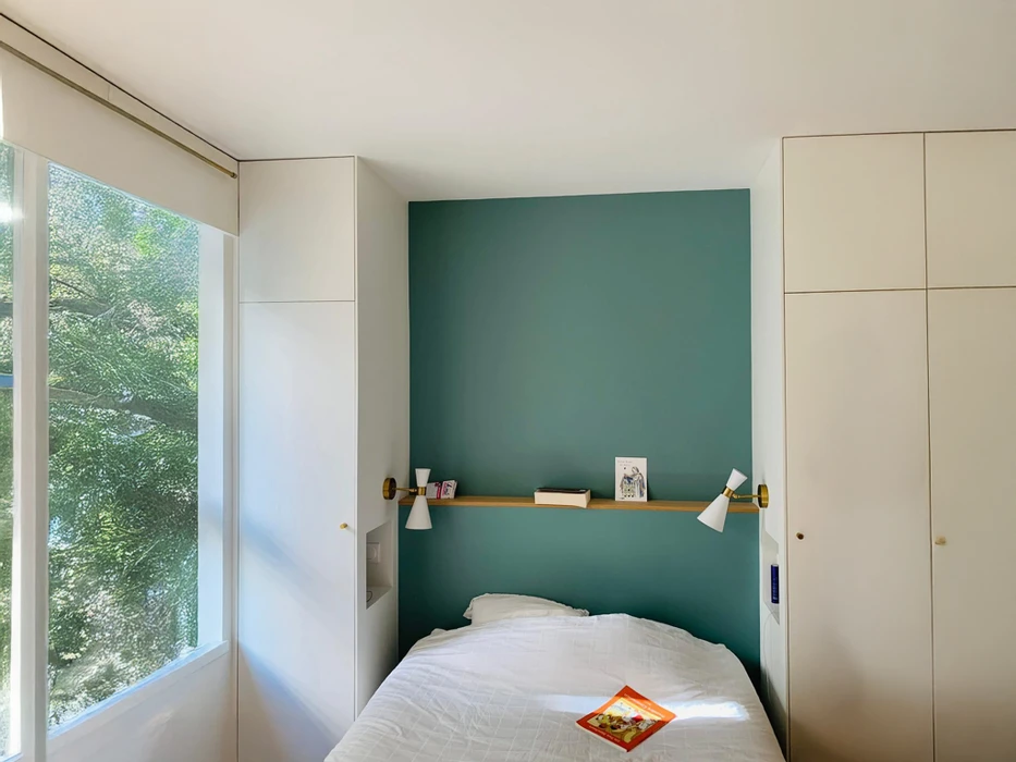 Intérieur d'appartement rénové avec salon lumineux aux murs blanc et rouge bordeaux