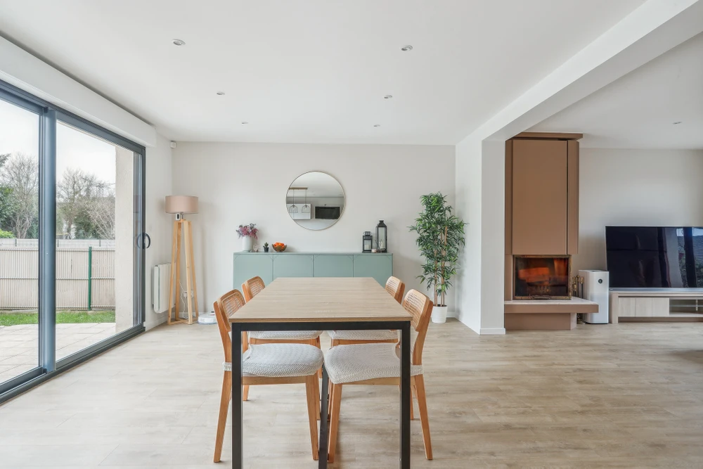 Intérieur d'appartement rénové avec salon lumineux aux murs blanc et rouge bordeaux