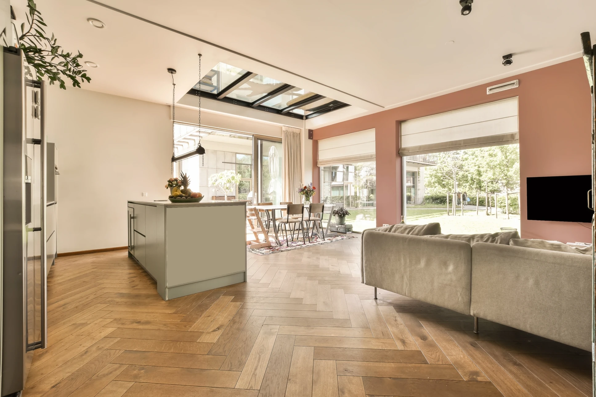 Le salon moderne est doté d'un poêle à bois noir, d'une télévision, d'une étagère blanche et d'une corbeille de bois, le tout sur un parquet en bois clair